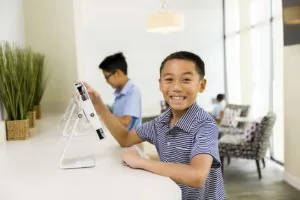 A young patient using an iPad in the waiting room of Normandy/Lakewood Dentistry in Jacksonville, Florida