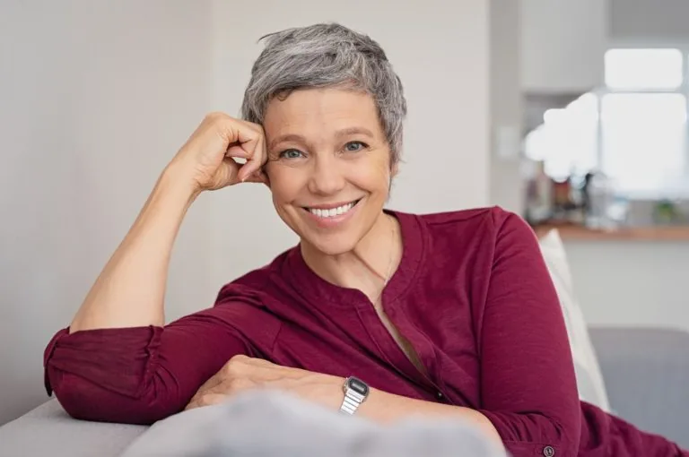 An older woman smiling with straight, white teeth