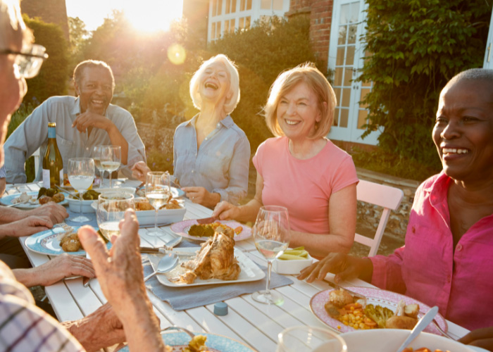 Group of older individuals sharing dinner and laughing