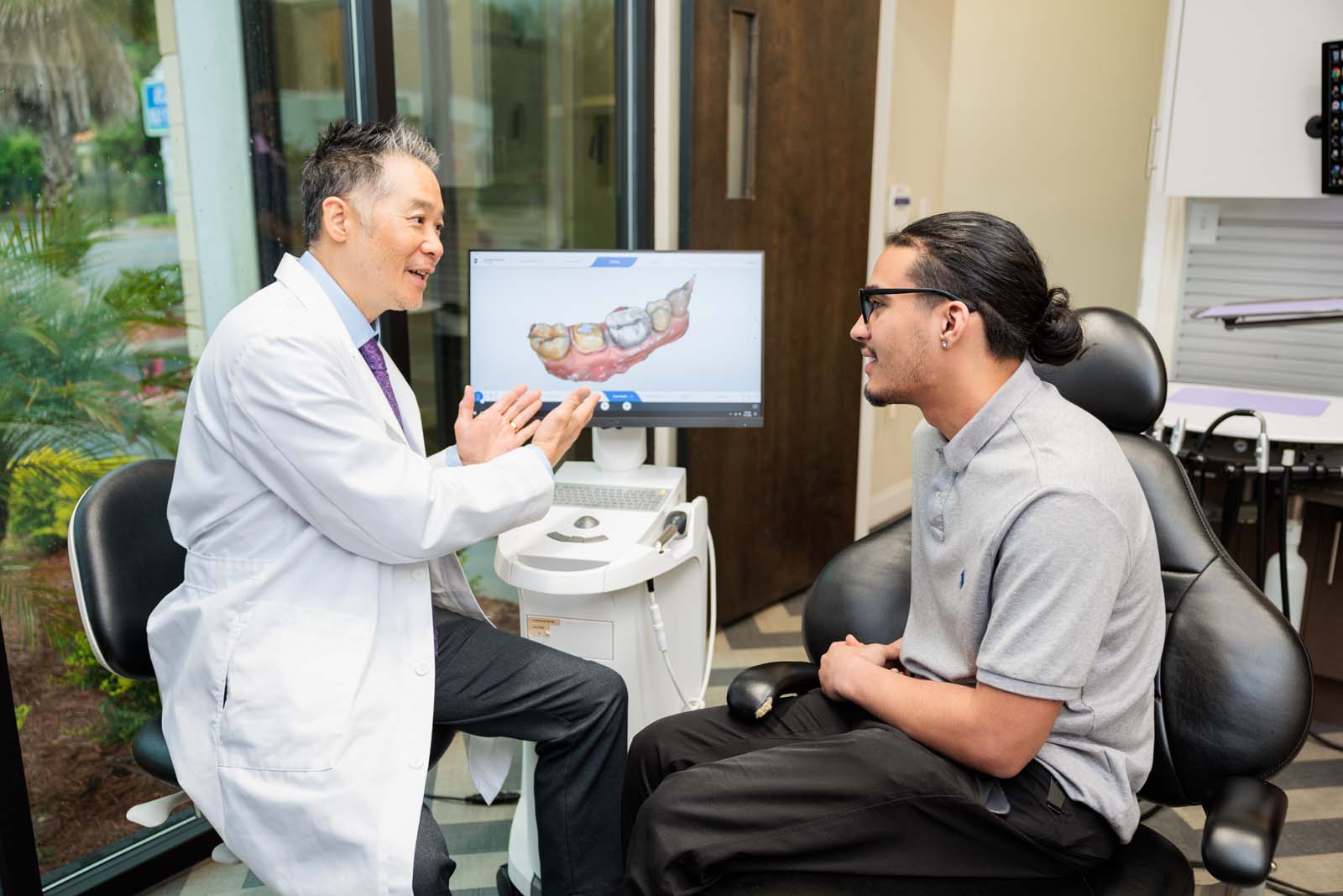 dentist showing patient some teeth in monitor