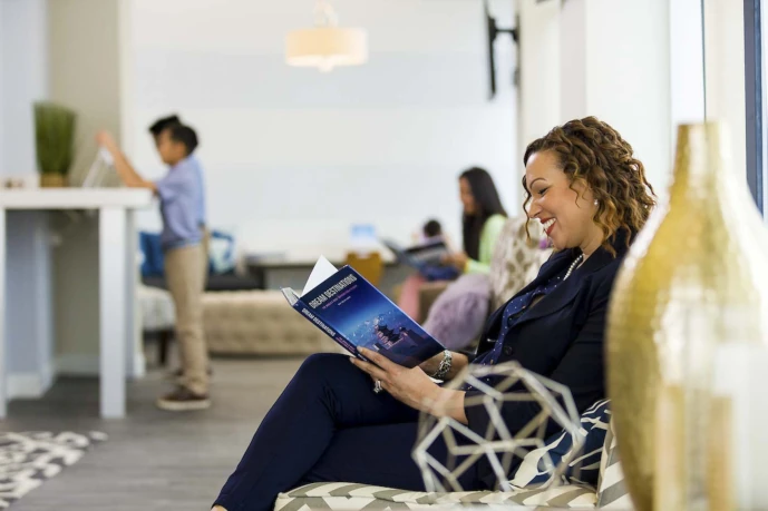 A patient sitting in the lobby area reading at Normandy Lake Dentistry in Jacksonville, FL.